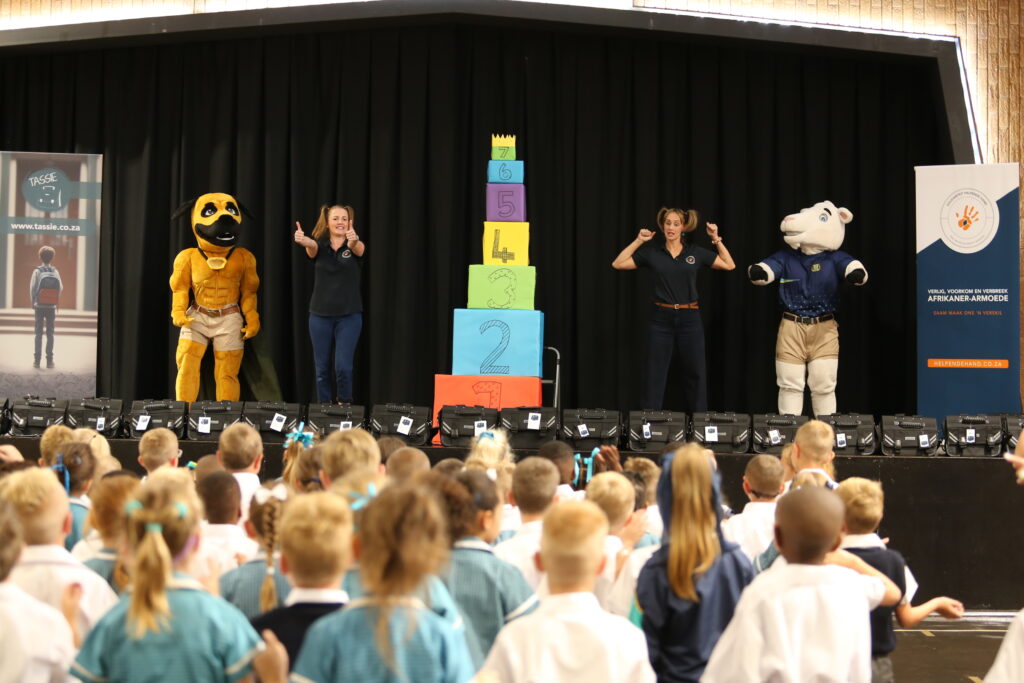 2) Die amptelike oorhandiging van 30 van die 2 000 skooltassies het op 14 Januarie by Laerskool Swartkop in Centurion plaasgevind, waar Helpende Hand se geliefde superheld, Braaf die Boerboel, saam met verteenwoordigers van die organisasie gehelp het om die tassies aan opgewonde graad 1-leerlinge te oorhandig.